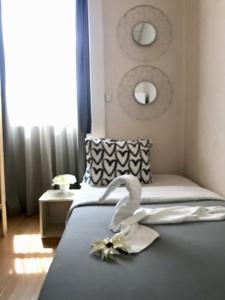 a bedroom with a bed with a swan decoration on it at Pensao Central in Matosinhos
