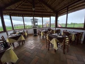 un restaurante con mesas y sillas y una chimenea en La botta vecchia - Delta of the Po - Private parking, en Porto Viro