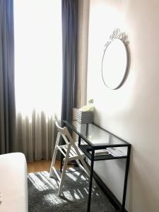 a desk with a chair and a mirror in a room at Pensao Central in Matosinhos