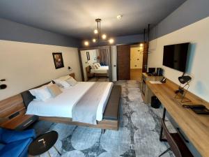 sypialnia z dużym łóżkiem i telewizorem w obiekcie Bucharest Comfort Suites Hotel w Bukareszcie