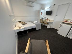 Mały pokój szpitalny z łóżkiem i biurkiem w obiekcie Charlton Motel w mieście Charlton