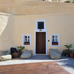 ein Haus mit einer braunen Tür und zwei Fenstern in der Unterkunft Caval II in Fira