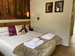 um quarto com uma cama com toalhas em Fox Lodge with Hot Tub em Cupar
