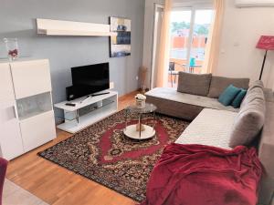 sala de estar con sofá y TV en Apartments Adriatic - Split Stobrec, en Split