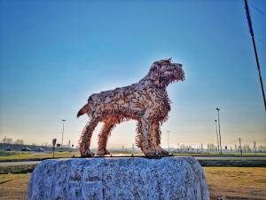 a statue of a dog standing on top of a rock at La botta vecchia - Delta of the Po - Private parking in Porto Viro