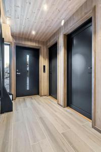 korytarz z czterema czarnymi drzwiami w budynku w obiekcie Panorama Hovden - New Cabin With Amazing Views w mieście Hovden