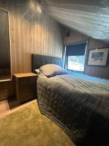 a bedroom with a bed and a television in it at Panorama Hovden - New Cabin With Amazing Views in Hovden