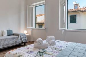a white room with a bed and a window at Palazzuolo Home in Florence