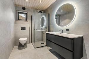 a bathroom with a sink and a toilet and a mirror at Panorama Hovden - New Cabin With Amazing Views in Hovden