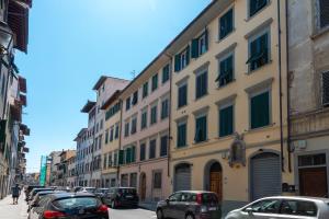 a row of buildings on a street with parked cars at Palazzuolo Home in Florence