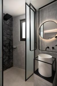 a bathroom with a sink and a mirror at Apikia Santorini in Pyrgos