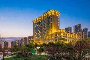 a tall yellow building in front of a city at Zhejiang Taizhou Marriott Hotel in Taizhou