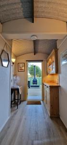a large room with a kitchen with a large doorway at Park Farm Holidays Glamping in Lyndhurst