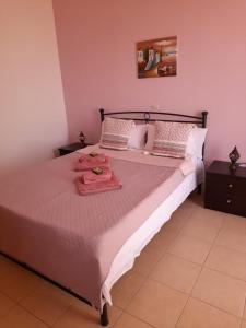 a bedroom with a large bed with pink walls at Villa Calli in Malia