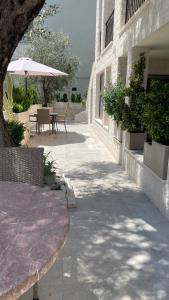 a patio with a table and chairs and an umbrella at Apartments Djuro Rafailovic in Budva