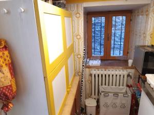 une cuisine avec une porte jaune et un four micro-ondes dans l'établissement Appartamento in casa antica, à Césane