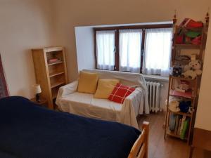 - un salon avec un canapé et une fenêtre dans l'établissement Appartamento in casa antica, à Césane