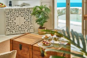 un soggiorno con tavolo e cibo sopra di Aqua Mykonos Suites - Adults Only a Tourlos