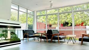 a living room with chairs and tables and windows at MAR24 Koh Tao Hotel in Ko Tao