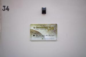 um sinal numa parede branca com uma etiqueta. em udammusu34 em Ragusa
