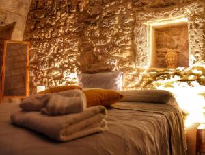 - une chambre avec un lit et un mur en pierre dans l'établissement udammusu34, à Raguse