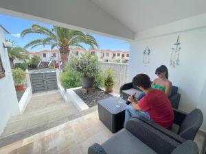 Dos mujeres sentadas en un sofá en una sala de estar en Estupendo adosado junto al mar, parking, terraza - Los Cancajos, en Breña Baja