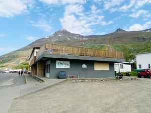 a small building with a mountain in the background at Studio Apartments in Seyðisfjörður