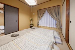 um quarto com uma cama grande e uma janela em R-house 2nd 横浜 em Higashi-kanagawachō