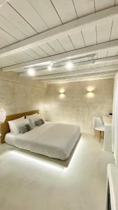 una camera con un grande letto bianco di Moustakas Beach Apartments ad Adámas
