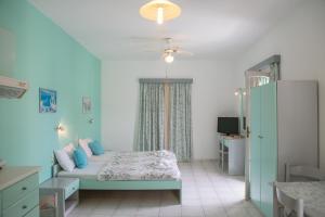 a bedroom with a bed and a ceiling fan at Mary's Studios in Agia Pelagia