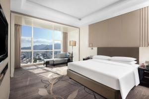 a bedroom with a white bed and a large window at Zhejiang Taizhou Marriott Hotel in Taizhou