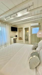 a large white bedroom with a large white bed at Moustakas Beach Apartments in Adamas