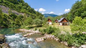 una casa en las montañas junto a un río en Resort Stari Malni, en Osilnica