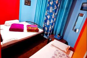 ein kleines Zimmer mit 2 Betten und einem Spiegel in der Unterkunft Bethel Homestay, Darjeeling in Darjeeling
