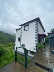 une maison blanche avec une clôture devant elle dans l'établissement Duplex House in Nature, à Trabzon