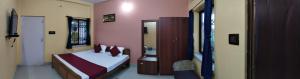 a bedroom with a bed and a mirror at Mayabon Resort Bolpur in Shānti Niketan