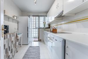 een keuken met witte apparatuur en een groot raam bij Apartamento Encantador vista Mar in Fuengirola