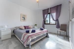 a white bedroom with a bed and a window at Apartamento Encantador vista Mar in Fuengirola