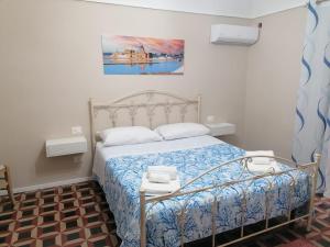 ein Schlafzimmer mit einem Bett und einem Gemälde an der Wand in der Unterkunft La Cocorita in Trapani