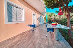a patio with a table and chairs on a deck at Mirror Beach Ksamil - Vila Zervo in Sarandë