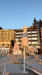 a group of chairs and umbrellas in front of a building at Esbjerg Hotel in Vlorë