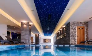 a swimming pool in a hotel with a ceiling filled with stars at Modern Apartments in Caesar Resort & SPA, Long Beach in Perivolia tou Trikomou