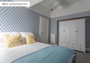 a bedroom with a bed and a blue wall at The Chymes Holiday Flats in Lytham St Annes