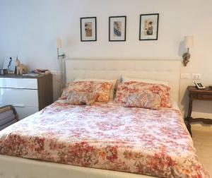 1 dormitorio con 1 cama grande con colcha de flores en Villa Serena, en Viareggio