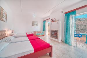 a bedroom with two beds and a fireplace at Mirror Beach Ksamil - Vila Zervo in Sarandë