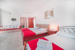a living room with two beds and a tv at Mirror Beach Ksamil - Vila Zervo in Sarandë