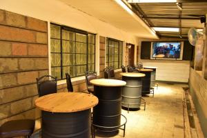 Wagon Wheel Hotel Eldoret في إلدوريت: صف من الطاولات والكراسي في غرفة مع تلفزيون