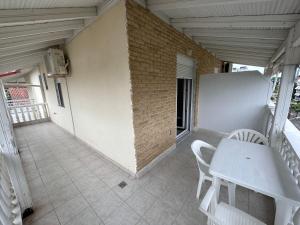 a patio with a table and chairs on a balcony at Villa Theodοra Superior in Olympic Beach