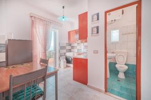 a bathroom with a toilet and a sink in a kitchen at Mirror Beach Ksamil - Vila Zervo in Sarandë