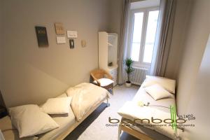 um pequeno quarto com 2 camas e uma janela em Bamboo Milano Umbria Apartment em Milão